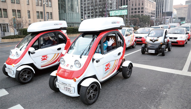 서울 광화문 우체국에서 노사상생 한마음 결의대회를 마친 집배원들이 초소형 전기차와 택배차량을 타고 거리 퍼레이드를 하고 있다.