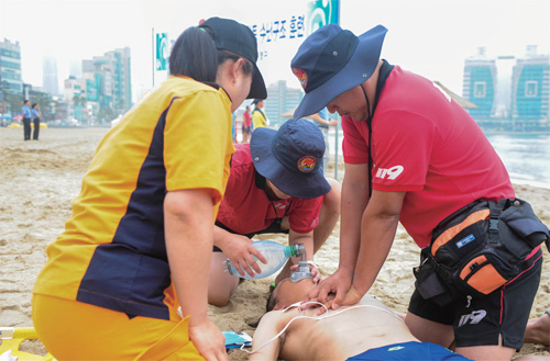 부산 광안리 해수욕장에서 구조대원들이 익수자에게 심폐소생술을 하고 있다.