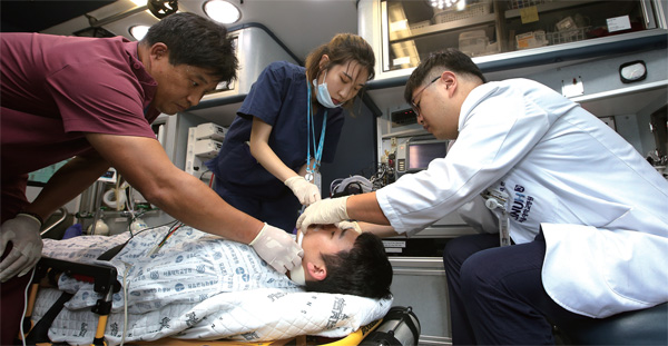 서울대병원 응급의료센터의 첨단 앰블런스에서 의료진이 환자를 병원으로 이송하며 응급조치를 하고 있다.