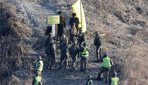 2018년 12월 12일 수요일 철원 휴전선 중부지방에 있는 북한 경비 초소를 조사하기 위해 비무장지대(DMZ) 내 군사분계선을 건너기 전에 한국군 병사가 북한 군인과 악수를 하고 있다. 남한과 북한은 작년 9월 군사협정의 일환으로 휴전선을 따라 경비 초소 일부를 제거했다.