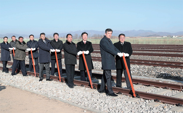 12월 26일 개성 판문역에서 진행된 ‘남북 철도·도로 연결 및 현대화 착공식’에서 남북 관계자들이 궤도 체결식을 하고 있다.