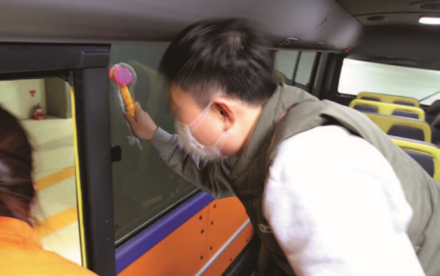 교통사고 체험관 내 버스체험 시설에서 참가자가 버스 내 비상 망치로 창문을 깨는 훈련을 하고 있다. 