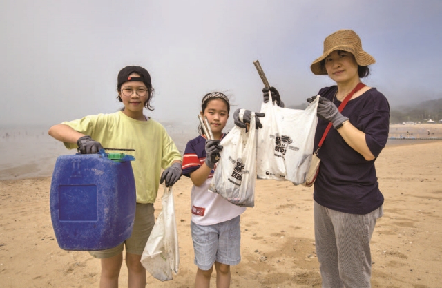 어머니와 함께 온 어린이 참가자들이 수거한 쓰레기를 들고 있다. 사진 C영상미디어
