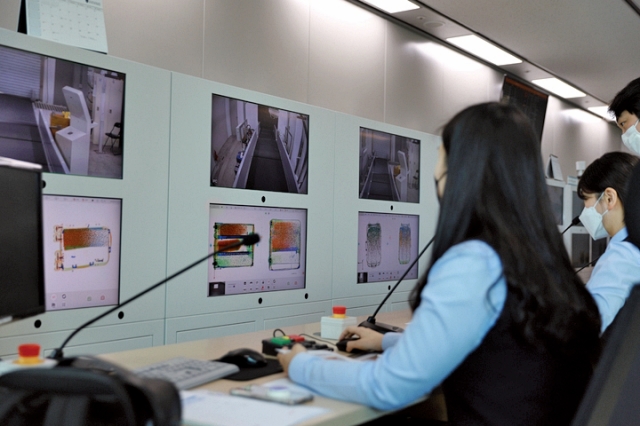 2023년 8월 1일 인천본부세관 직원들이 3D X-레이 검색기를 통해 승객들의 수하물을 판독하고 있다. 사진 인천공항본부세관