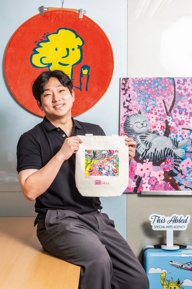‘디스에이블드’ 김현일 대표가 발달장애 예술인의 작품이 담긴 대통령실 굿즈(에코백)를 선보이고 있다. 사진 C영상미디어