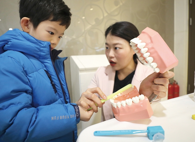 서울 서초구청 대강당에서 건강검진을 받는 어린이가 구강관리 설명을 듣고 있다. 사진 뉴시스
