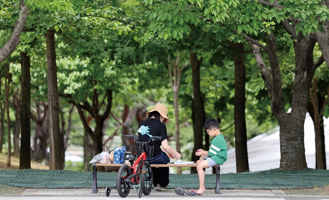 5월 27일 대구 수성구 대구스타디움 광장 나무 그늘에서 시민들이 휴식을 취하고 있다. 사진 뉴시스