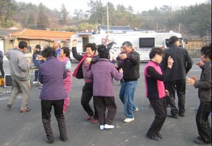 지난 7일 강진 산정마을 주민들이 다 같이 일어나 흥겨운 춤 잔치를 벌이고 있다.