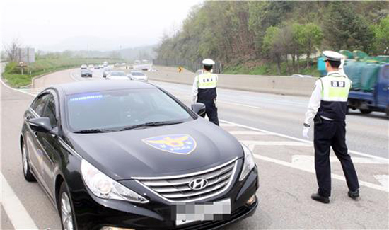 암행순찰차와 그 옆에서 교통 법규를 단속하고 있는 경찰들의 모습.(사진=경기남부경찰청)