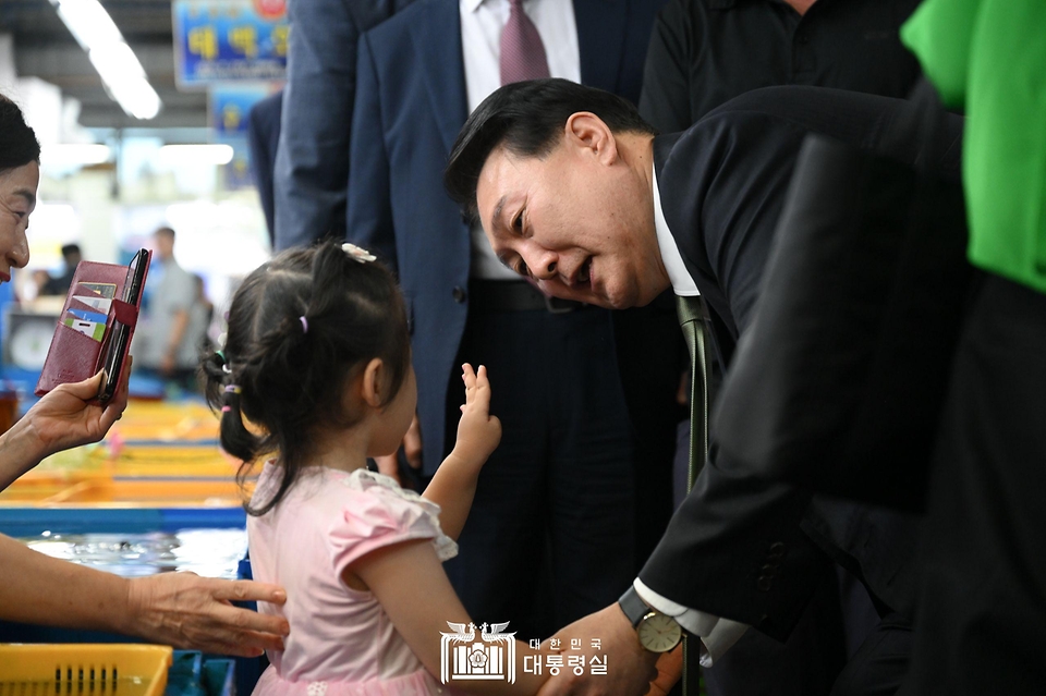 윤석열 대통령이 14일 부산 수영구 민락어민활어직판장을 방문해 어린이와 인사하고 있다.