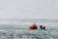 해군 장병들이 22일 경남 창원시 진해해군기지에서 주관한 연합·합동 EOD 훈련에서 바다 위 기뢰 표면에 폭약을 설치하고 있다.