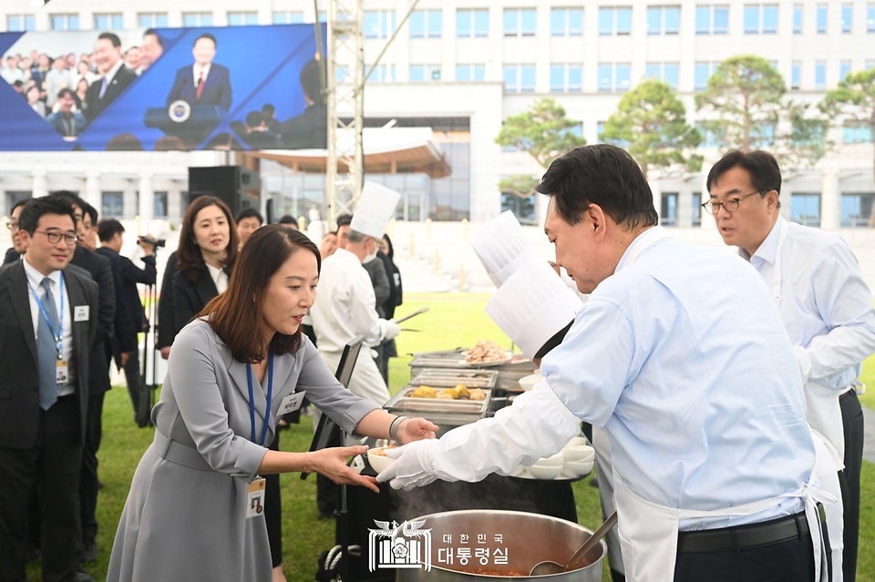 윤석열 대통령이 24일 서울 용산 대통령실 잔디마당에서 열린 ‘대통령의 저녁 초대’ 출입기자단 초청 만찬 간담회에서 취재진에게 김치찌개를 배식하고 있다.