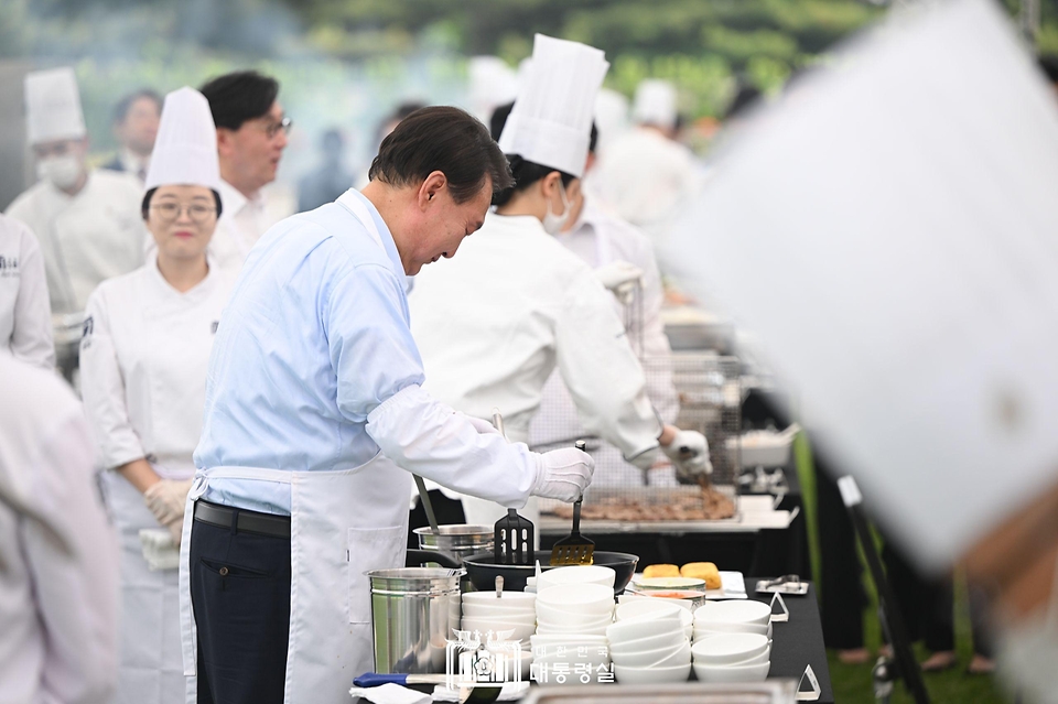 윤석열 대통령이 24일 서울 용산 대통령실 잔디마당에서 열린 ‘대통령의 저녁 초대’ 출입기자단 초청 만찬 간담회에서 계란말이를 만들고 있다.