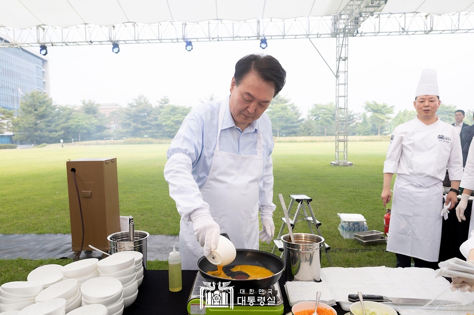 윤석열 대통령이 24일 서울 용산 대통령실 잔디마당에서 열린 ‘대통령의 저녁 초대’ 출입기자단 초청 만찬 간담회에서 계란말이를 만들고 있다.