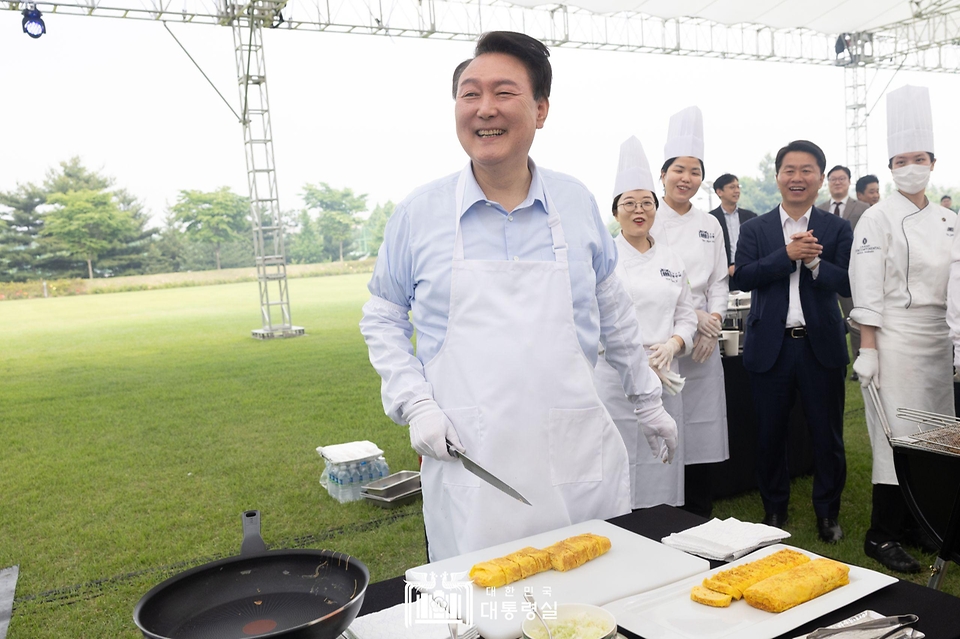 윤석열 대통령이 24일 서울 용산 대통령실 잔디마당에서 열린 ‘대통령의 저녁 초대’ 출입기자단 초청 만찬 간담회에서 계란말이를 만들고 있다.