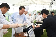 윤석열 대통령이 24일 서울 용산 대통령실 잔디마당에서 열린 ‘대통령의 저녁 초대’ 출입기자단 초청 만찬 간담회에서 취재진에게 김치찌개를 배식하고 있다.