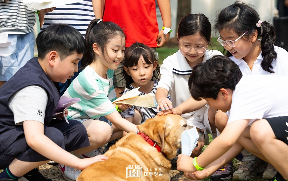 어린이들이 5일 서울 용산어린이정원에서 열린 ‘어린이 환경·생태 교육관’ 개관 행사에서 김건희 여사의 반려견 새롬이를 쓰다듬고 있다.