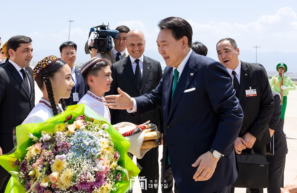 윤석열 대통령이 10일(현지시간) 투르크메니스탄 아시가바트 공항에 도착해 투르크메니스탄 전통의상을 입은 어린이들과 인사하고 있다.
