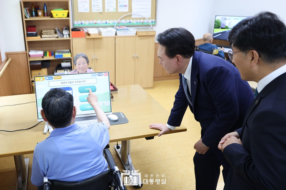 윤석열 대통령이 21일 경기도 수원시 수원보훈요양원 내 작업치료실을 방문해 단어놀이를 통한 인지훈련 프로그램을 참관하고 있다.