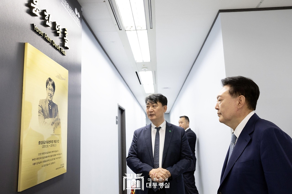 윤석열 대통령이 13일 서울 중구 중앙응급의료센터를 찾아 윤한덕홀 외벽에 걸린 고(故) 윤한덕 전 센터장 소개 현판을 바라보고 있다.