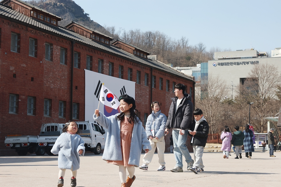 제106주년 3·1절을 앞둔 27일 서울 서대문형무소역사관을 찾은 시민들이 태극기를 들어보이고 있다. 