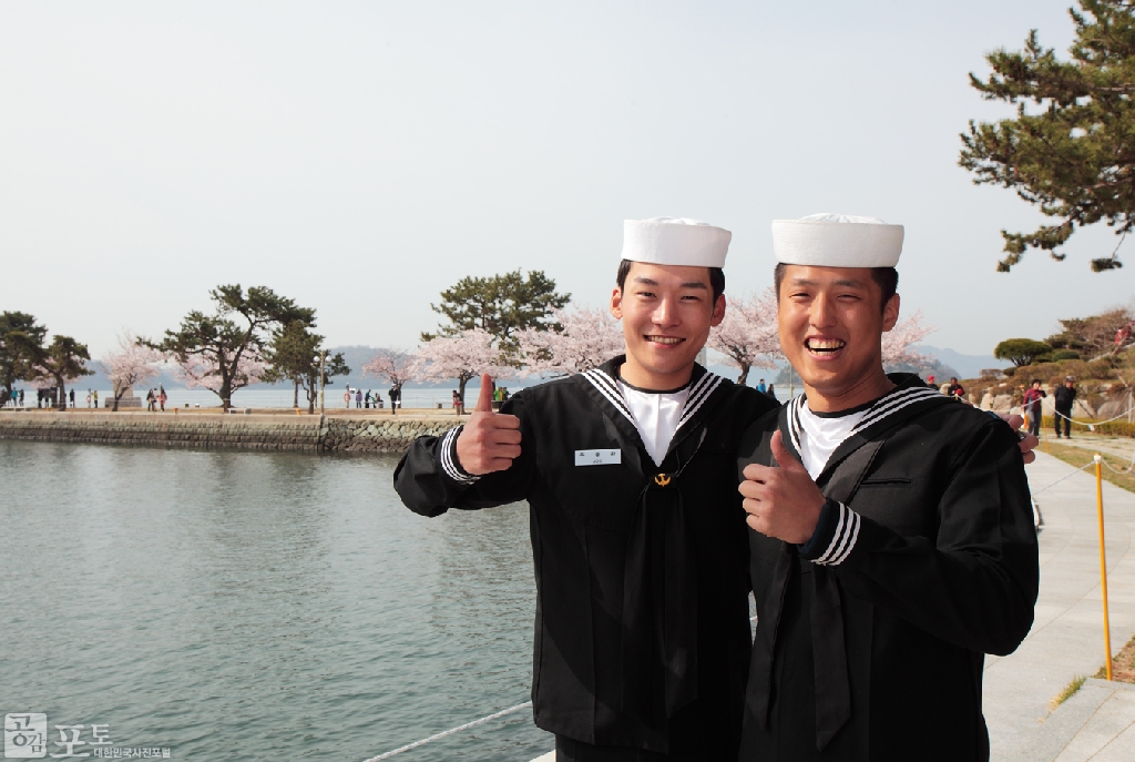 화창한 봄날 해군사관학교를 찾은 상춘객들을 안내하면서 환하게 웃음을 짓고 있는 병사들.