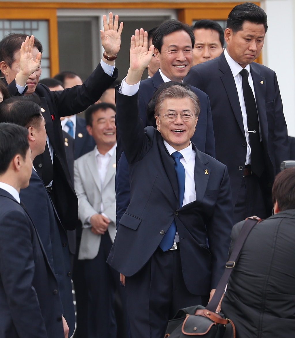 10일 오전 서울 동작구 국립현충원에서 참배를 마치고 나온 문재인 대통령이 시민들을 향해 손을 들어 인사하고 있다. 