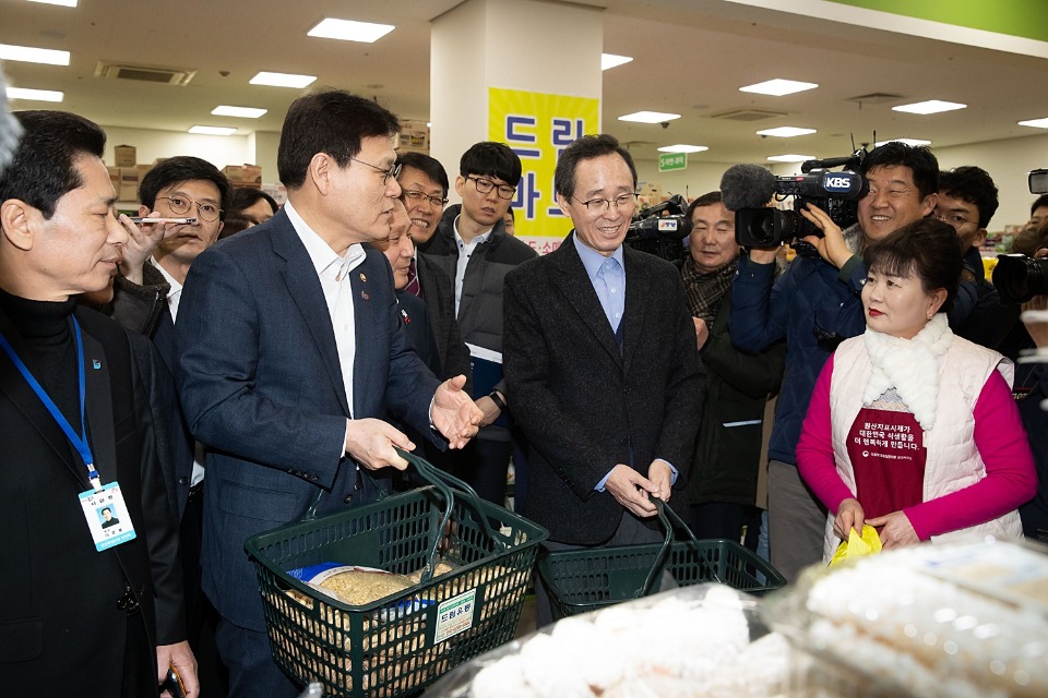 최종구 금융위원장(왼쪽에서 두 번째)과 송하진 전북 도지사(왼쪽에서 세 번째)가 군산 공설시장에서 정월대보름을 맞아 물품을 구입하고 있다.