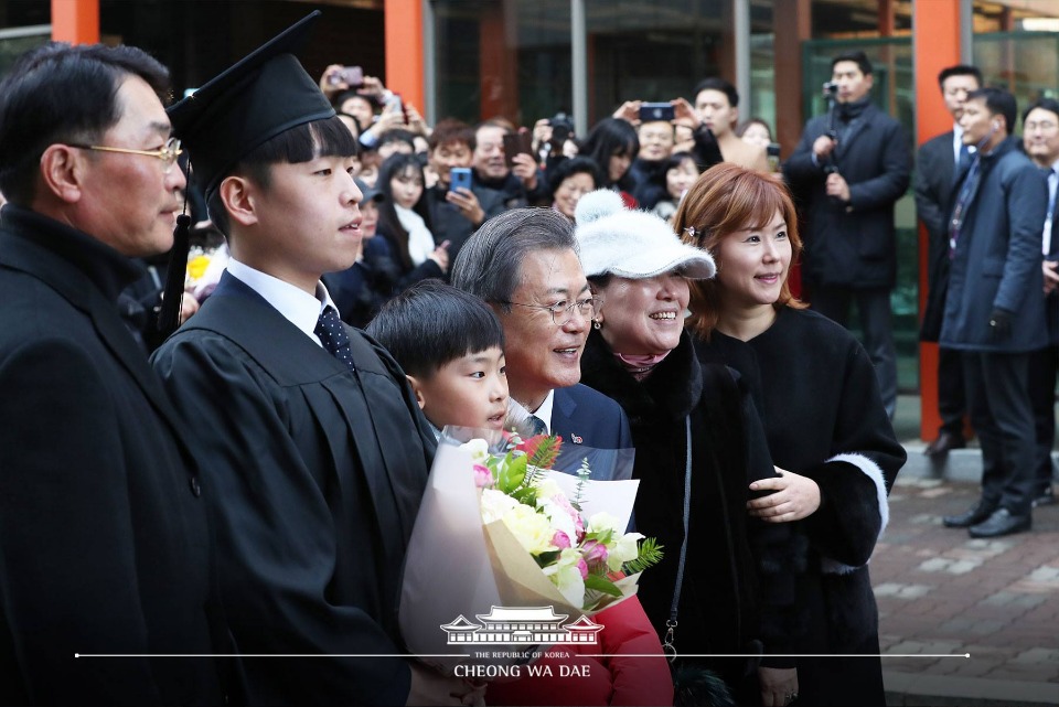 문재인 대통령이 21일 오전 경기도 부천시 유한대학교에서 열린 졸업식에서 한 졸업생 가족들과 기념 촬영을 하고 있다. (사진출처 : 청와대 페이스북)