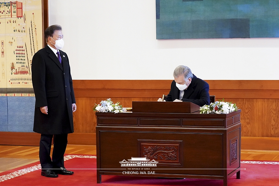 문재인 대통령이 17일 청와대에서 국빈 방문한 샵카트 미르지요예프 우즈베키스탄 대통령의 방명록 작성을 지켜보고 있다.