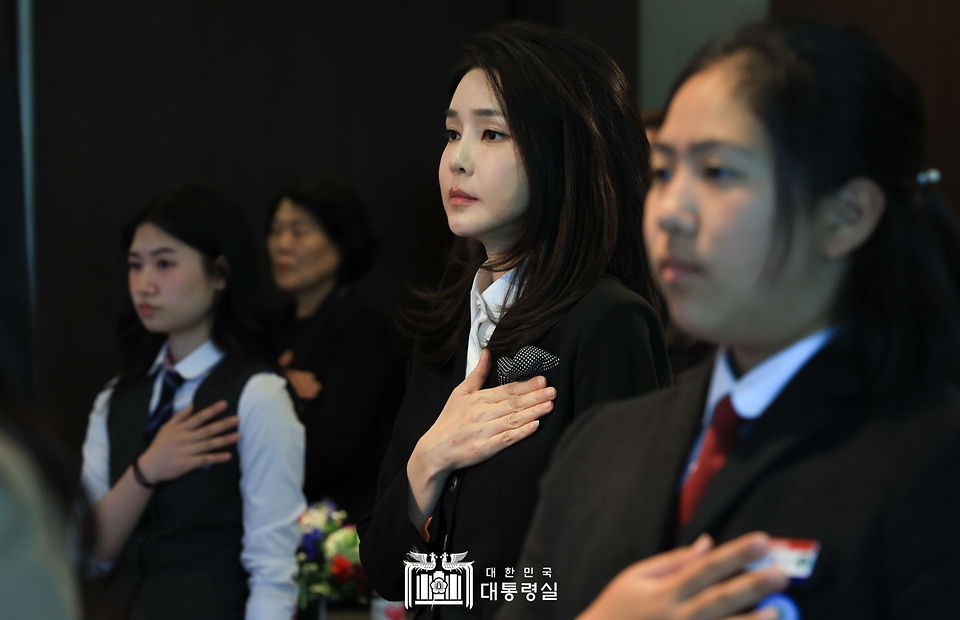 김건희 여사가 13일 서울 여의도 63컨벤션센터에서 열린 ‘히어로즈 패밀리 프로그램 출범식’에서 국기에 대한 경례를 하고 있다.
