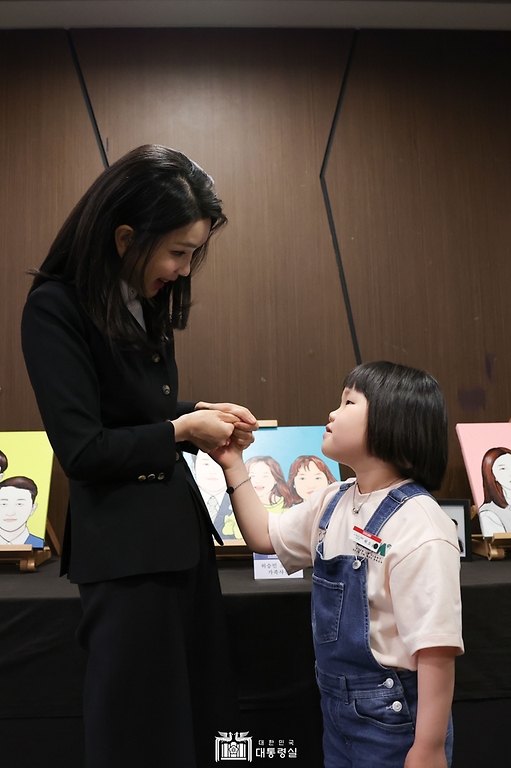 김건희 여사가 13일 서울 여의도 63컨벤션센터에서 열린 ‘히어로즈 패밀리 프로그램 출범식’에서 고 허승민 소방위의 자녀와 대화하고 있다.