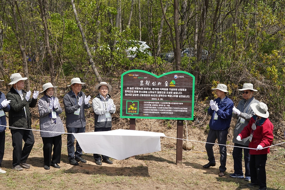 남성현 산림청장이 26일 경기 여주시 상거동에서 열린 ‘문학인과 함께하는 탄소중립 나무심기 행사’에서 참가자들과 안내판 제막을 하고 있다.