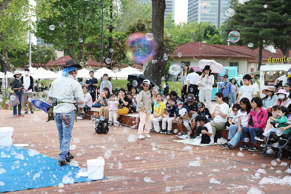 <p>13일 서울 용산구 용산어린이정원에서 시민들이 버블 공연을 관람하고 있다.<p>