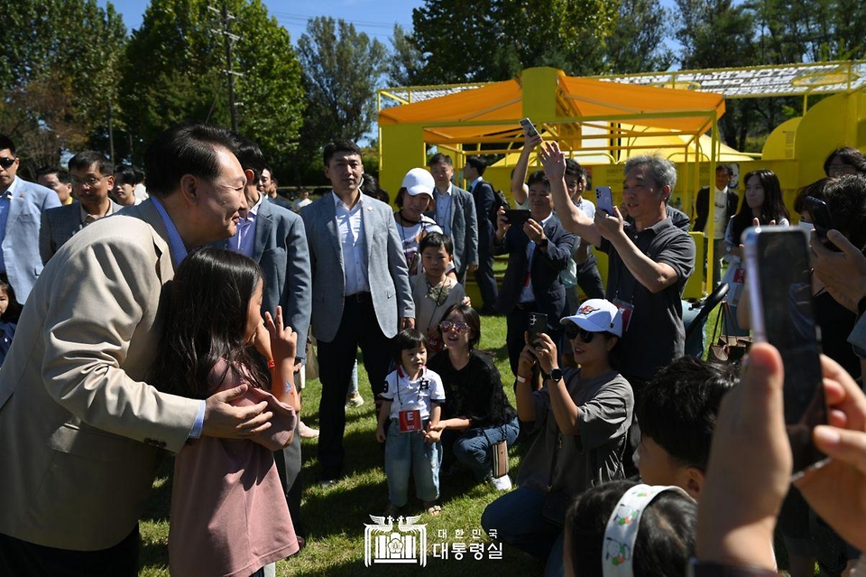 윤석열 대통령이 24일 서울 용산어린이정원에서 열린 ‘추석맞이 팔도장터’에 방문해 어린이와 기념촬영을 하고 있다.