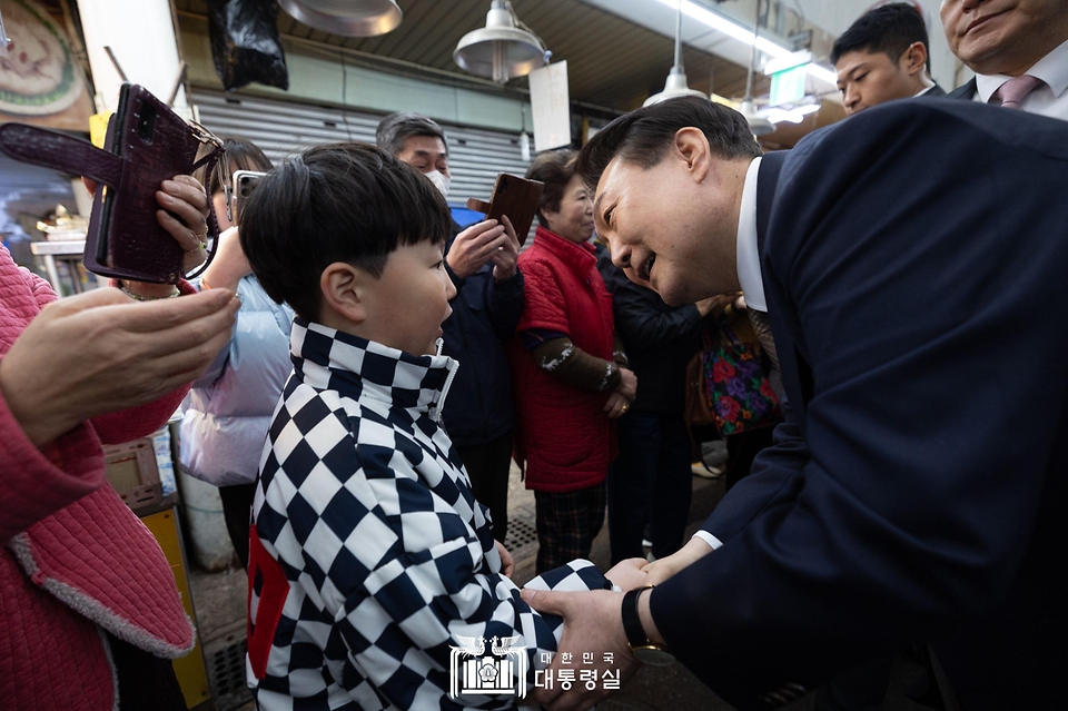 윤석열 대통령이 22일 경남 창원시 마산합포구 마산어시장을 방문해 한 어린이와 인사를 나누고 있다.