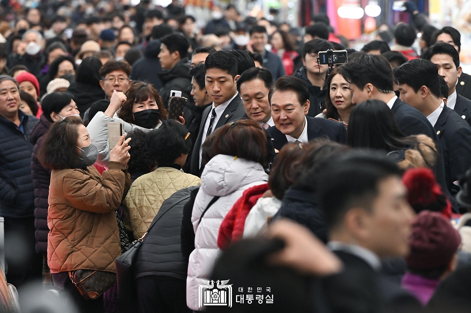 윤석열 대통령이 22일 경남 창원시 마산합포구 마산어시장을 방문해 시민들과 인사를 나누고 있다.