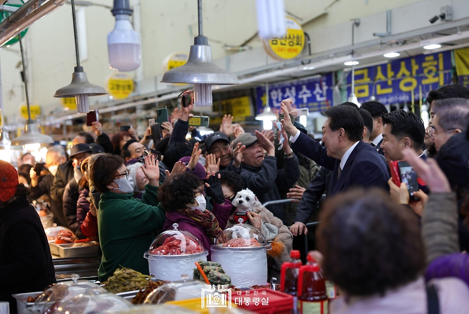 윤석열 대통령이 22일 경남 창원시 마산합포구 마산어시장을 방문해 상인 및 시민들과 인사를 나누고 있다.
