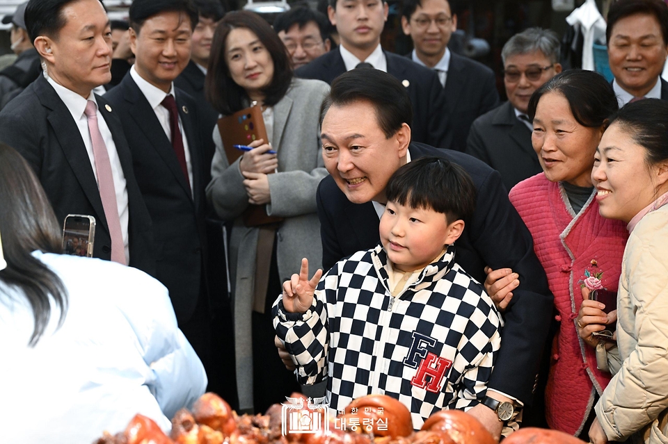 윤석열 대통령이 22일 경남 창원시 마산합포구 마산어시장을 방문해 시민들과 기념 촬영을 하고 있다.