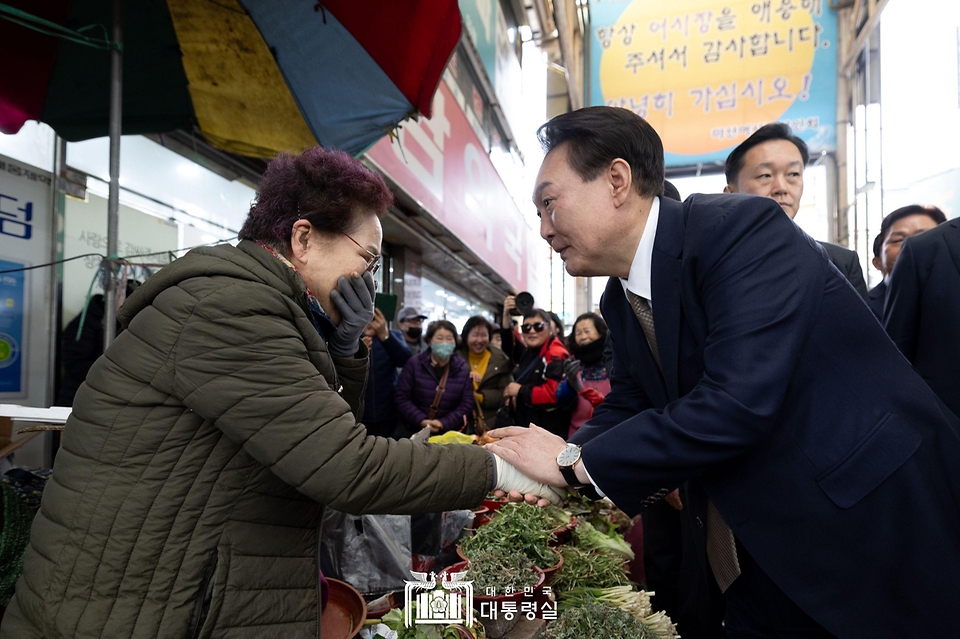 윤석열 대통령이 22일 경남 창원시 마산합포구 마산어시장을 방문해 상인과 인사를 나누고 있다.