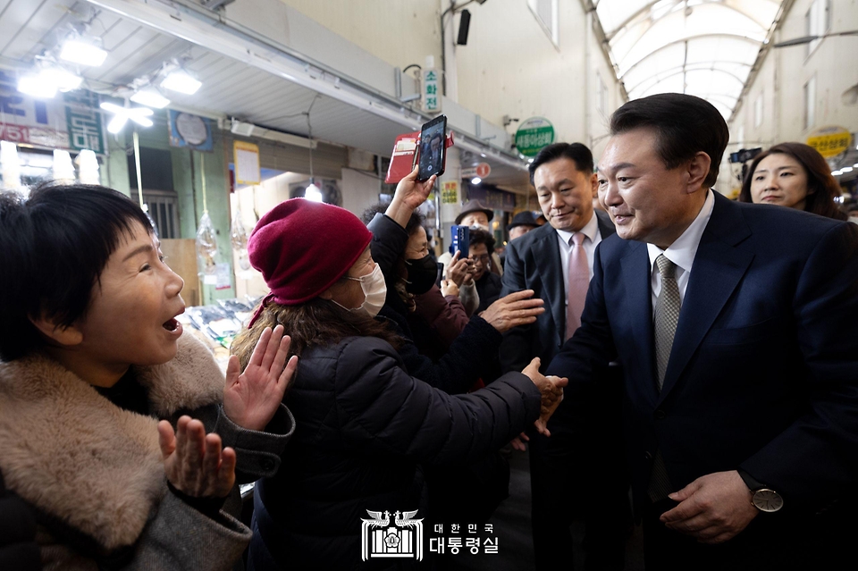윤석열 대통령이 22일 경남 창원시 마산합포구 마산어시장을 방문해 상인 및 시민들과 인사를 나누고 있다.