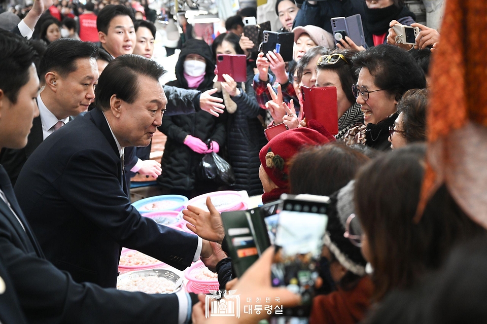 윤석열 대통령이 22일 경남 창원시 마산합포구 마산어시장을 방문해 시민들과 인사를 나누고 있다.