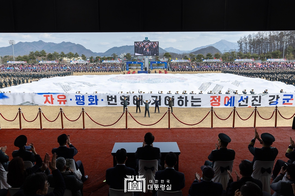 윤석열 대통령이 28일 충북 괴산군 육군학생군사학교에서 열린 ‘2024년 학군장교 임관식’에서 대형 태극기를 펼쳐보이는 충성다짐 퍼포먼스를 참관하고 있다.