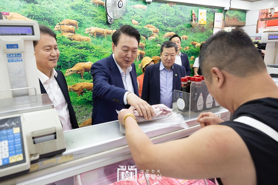 윤석열 대통령이 10일 서울 서대문구 영천시장을 찾아 정육점에서 돼지고기를 구매하고 있다. 