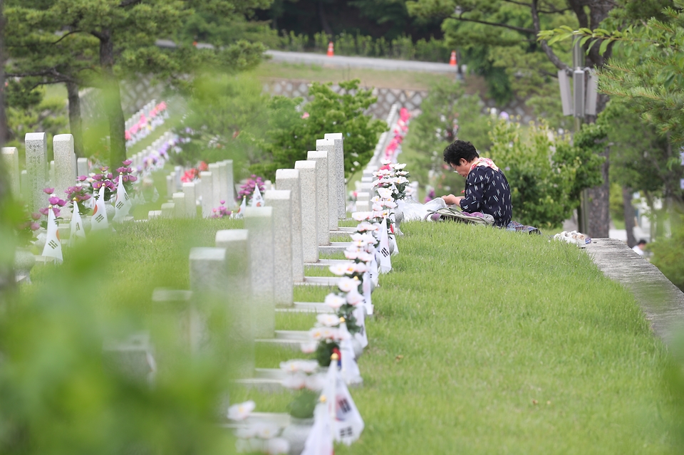 호국보훈의 달 6월을 맞아 7일 서울 동작구 국립서울현충원을 찾은 한 참배객이 묘역을 찾아 참배하고 있다.