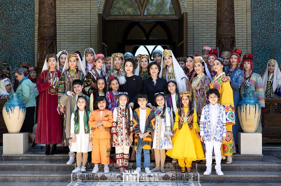 김건희 여사가 14일(현지시간) 우즈베키스탄 타슈켄트 대통령궁 히바동에서 지로아트 미르지요예바(Ziroat Mirziyoyeva) 우즈베키스탄 영부인 및 배우자 문화 프로그램 참가자들과 기념 촬영을 하고 있다.