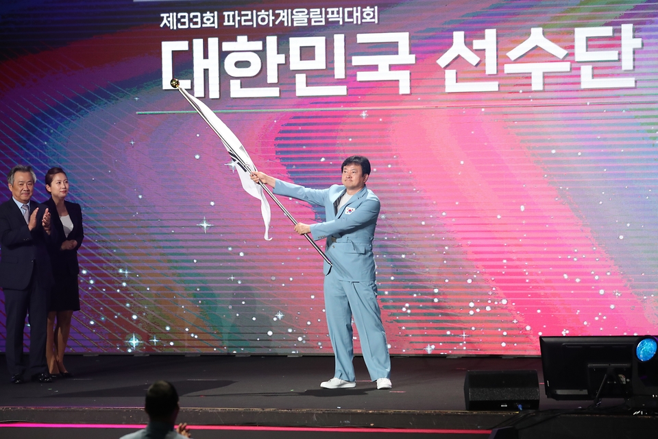 정강선 파리올림픽 선수단장이 9일 서울 송파구 올림픽공원 올림픽홀에서 열린 2024 파리하계올림픽 선수단 결단식에서 단기를 흔들고 있다. 