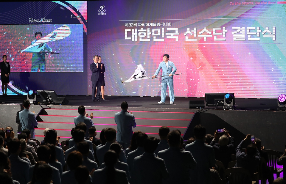 정강선 파리올림픽 선수단장이 9일 서울 송파구 올림픽공원 올림픽홀에서 열린 2024 파리하계올림픽 선수단 결단식에서 단기를 흔들고 있다. 