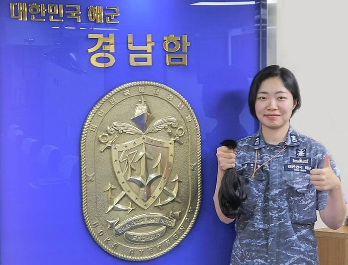15일 해군3함대 경남함 김하늘 중위가 2년 동안 기른 기부할 모발을 들어 보이고 있다. 