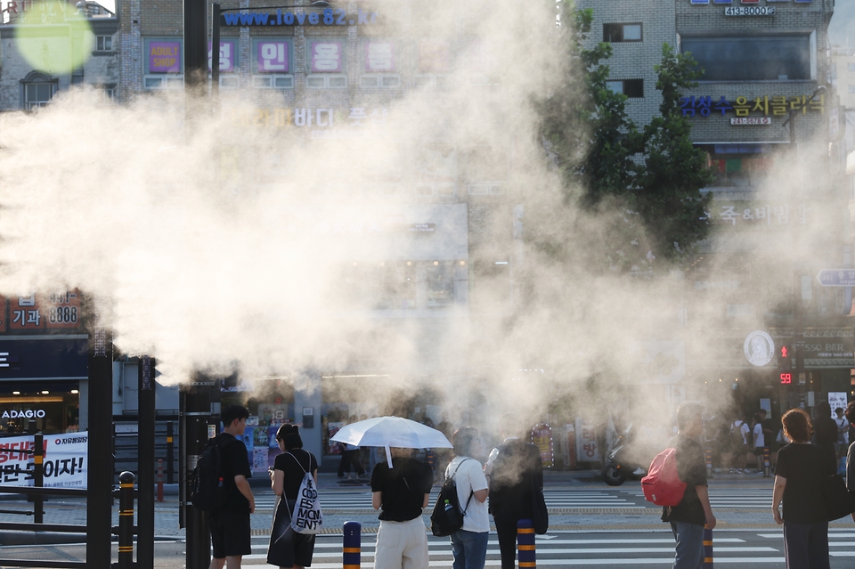 전국적으로 폭염주의가 발효된 가운데 4일 오후 부산 동구 부산역 앞에서 시민들이 쿨링포그(안개형 냉각수)가 작동하는 횡단보도를 건너고 있다.